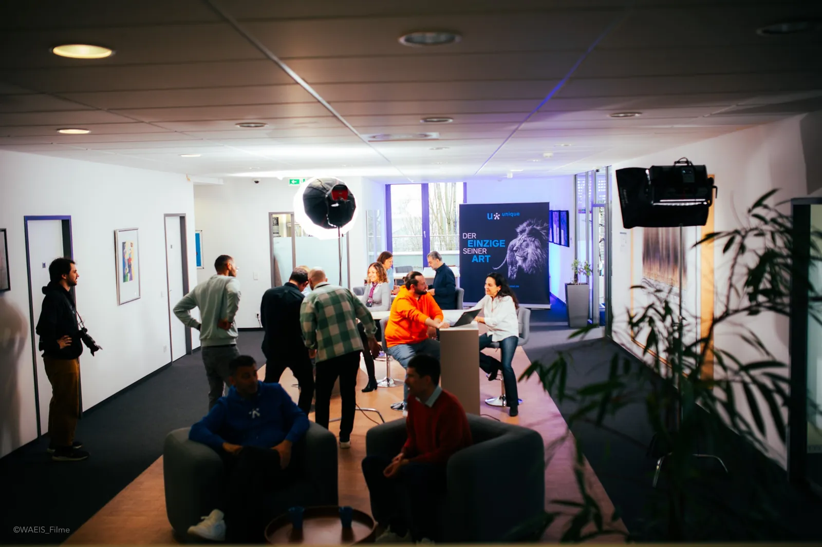 Blick in die Büroräume von unique beim Dreh, Team und Kamera im Hintergrund