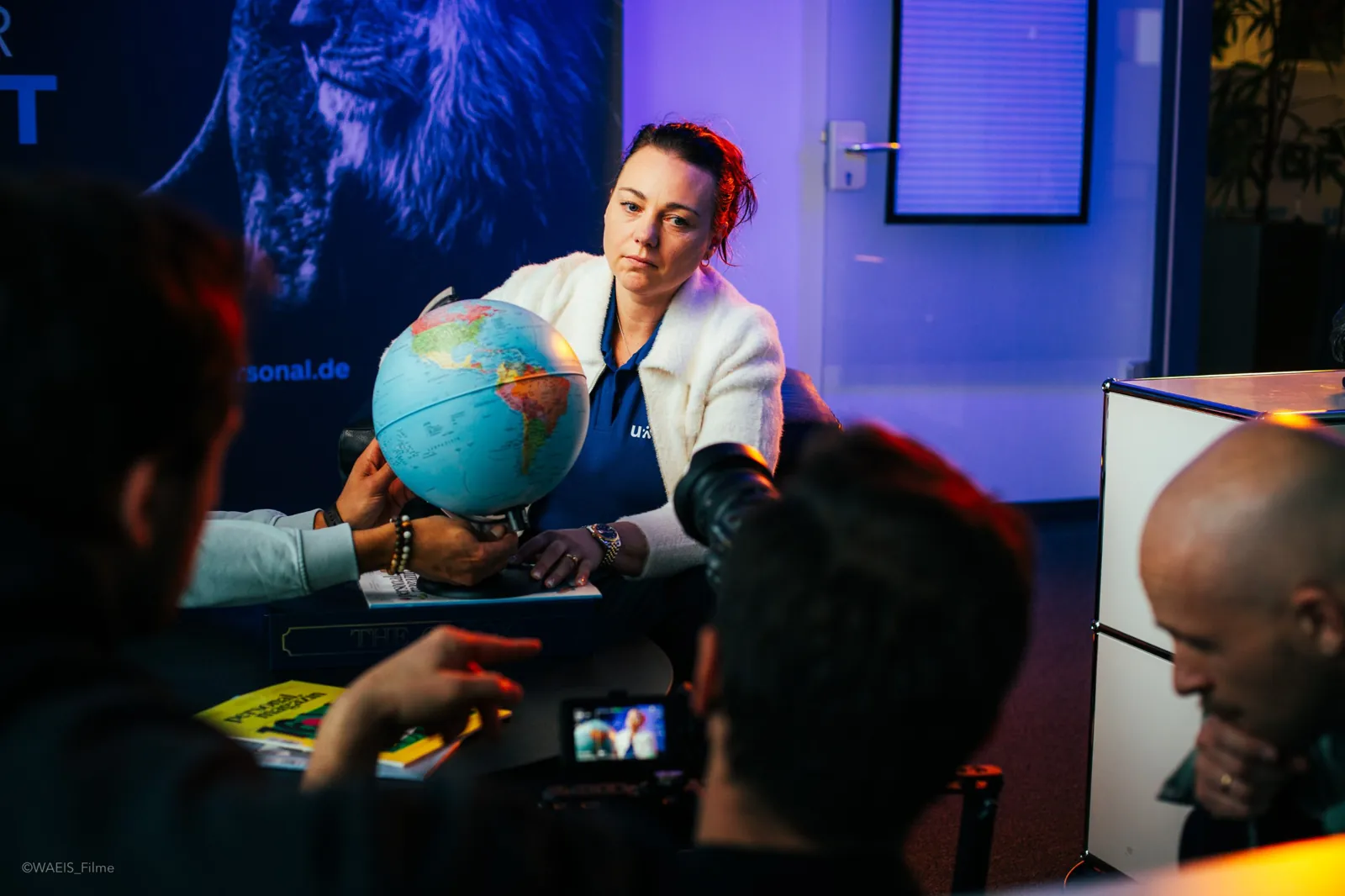 Dreh mit einer Protagonistin und einem Globus, im Vordergrund Kameras