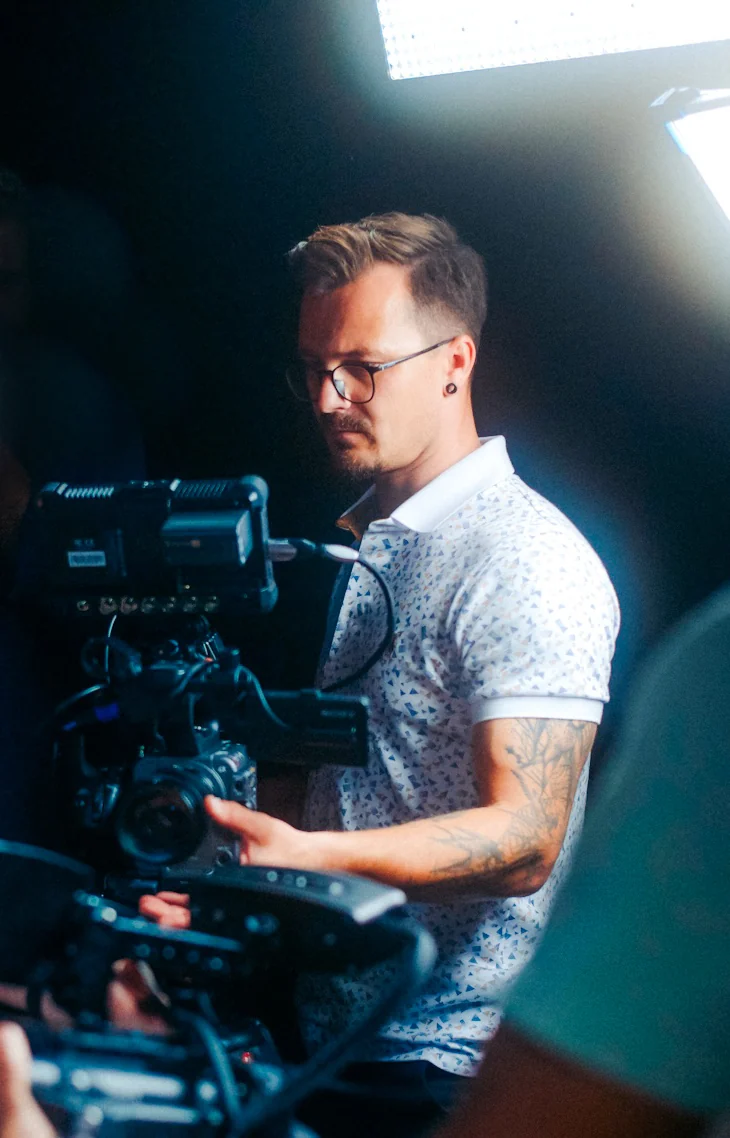 Anton Leis konzentriert hinter einer Kamera am Set